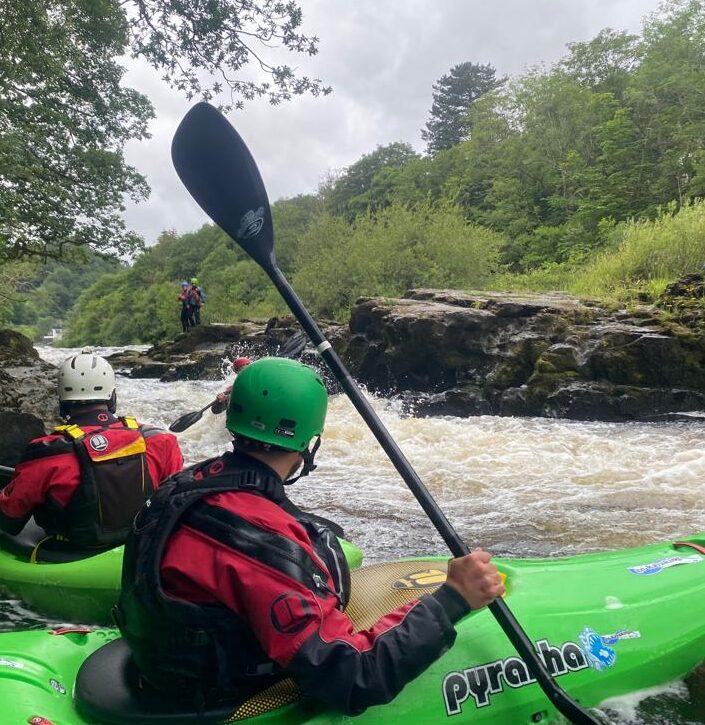 Kayakers navigating a turbulent river